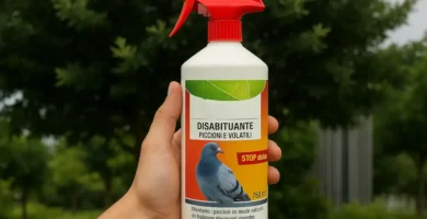 La mano izquierda de una persona sosteniendo una botella con gatillo pulverizador con una paloma en la etiqueta, da a entender que es uno de los muchos productos para ahuyentar palomas en formato líquido y/o químico que existen en el mercado, de fondo una zona ajardinada con arboles